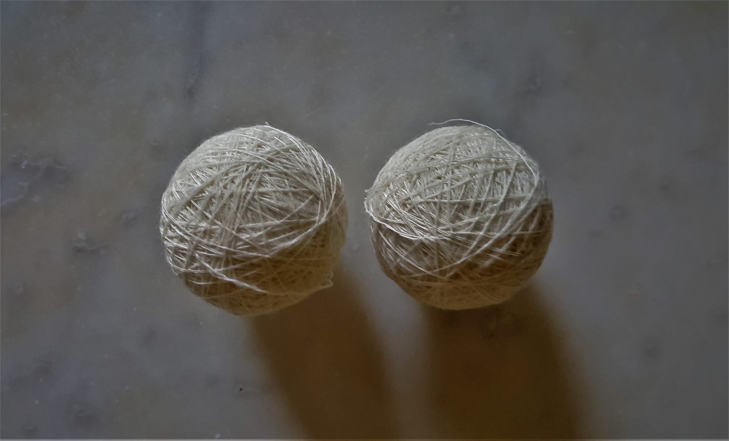 Two balls of white wool thread (dari)