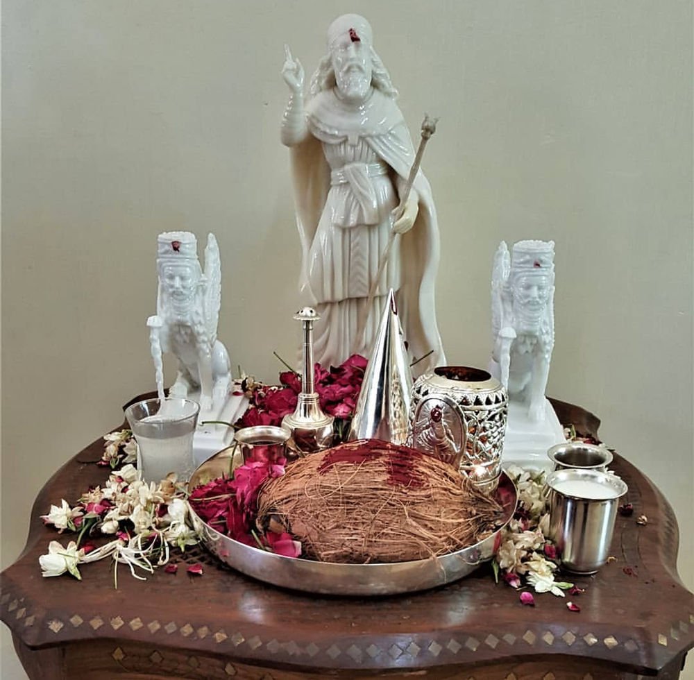 A Parsi ses tray with garlands, silver and a white statue